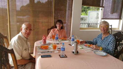 Eine Gruppe von Menschen, die an einem Tisch sitzen und Essen essen. in der Unterkunft 36 Bed & Breakfast in Kandy