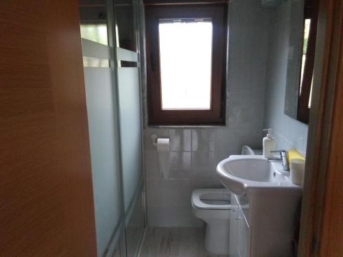 ein Bad mit einem Waschbecken, einem WC und einem Fenster in der Unterkunft La Maria Diego in Peñamellera Baja