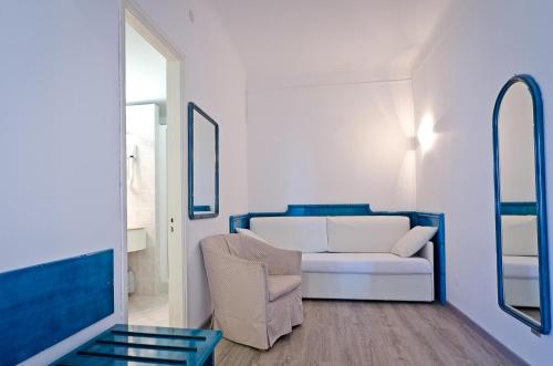 a living room with a white couch and a chair at Hotel Ariston Montecarlo in Sanremo