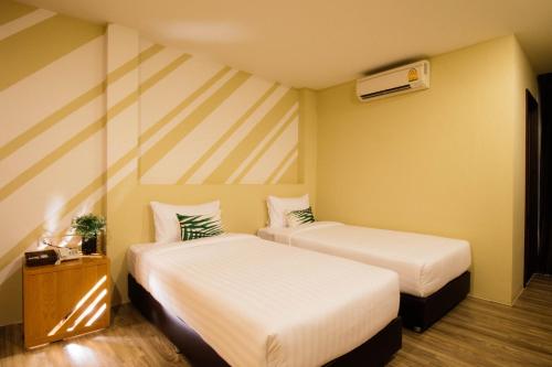 una camera d'albergo con due letti e una stufa di The Pat Hotel a Jomtien Beach