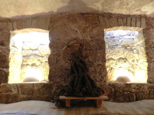a stone wall with two windows in a room at Casa.Peiso in Mörbisch am See