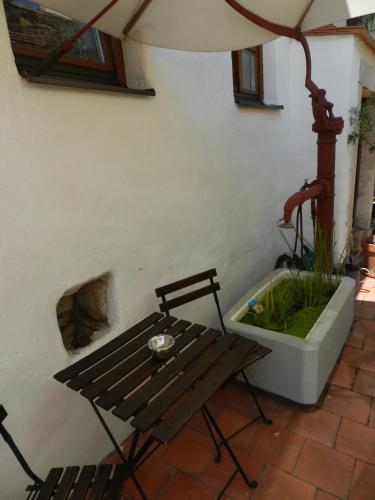 a wooden bench sitting on a patio with a fountain at Casa.Peiso in Mörbisch am See