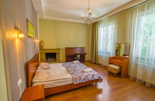 a bedroom with a bed and a desk and a fireplace at Silver Hotel in Tbilisi City