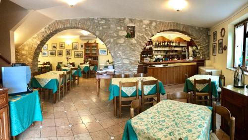 un restaurante con mesas y sillas y una pared de piedra en Locanda Speranza, en Torri del Benaco