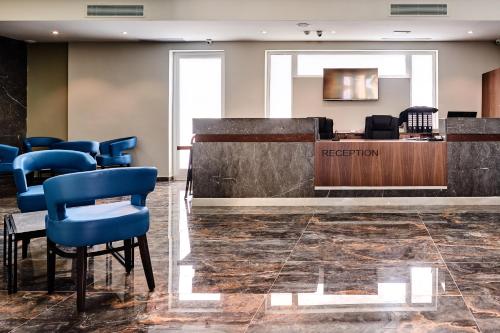 a waiting room with a reception desk and blue chairs at The District Hotel in St Julian's