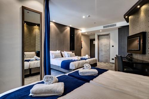 ein Hotelzimmer mit 2 Betten und einem Spiegel in der Unterkunft The District Hotel in St Julian's