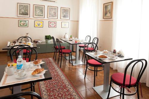 uma sala de jantar com mesas e cadeiras com comida em Hotel Gardenia em Forlì