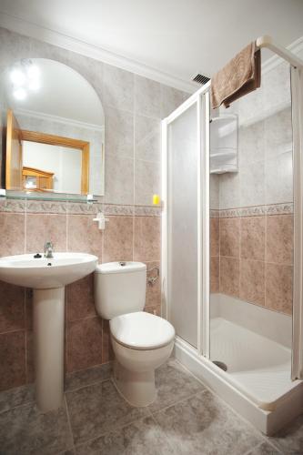 a bathroom with a toilet and a sink and a shower at Viviendas Vacacionales Marcial in Morro del Jable
