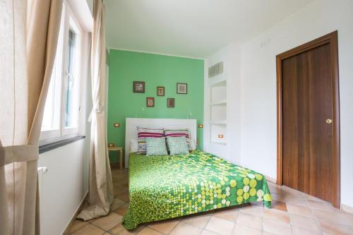 a bedroom with a bed with a green wall at Crispi Promenade in Cava deʼ Tirreni