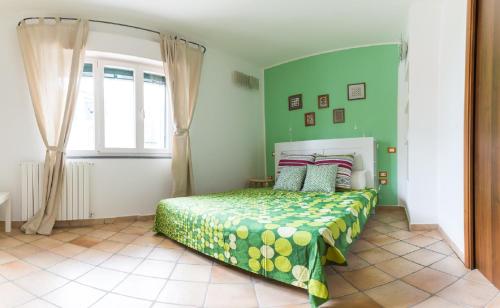 una camera da letto con un letto con pareti verdi e una finestra di Crispi Promenade a Cava deʼ Tirreni