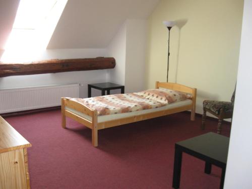 a small bedroom with a bed and a table at Penzion u Patrona in Kouřim