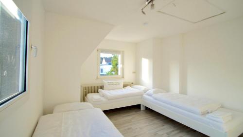 a white room with two beds and a window at GL 234 in Bergisch Gladbach