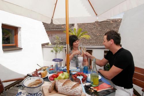 a man and woman sitting at a table with food at Casa.Peiso in Mörbisch am See