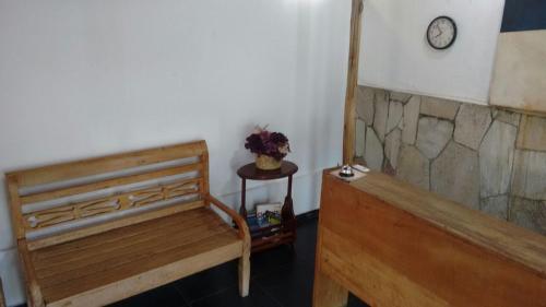 a room with a bench and a clock on the wall at Hotel Aldeia Cerrado in Goiânia