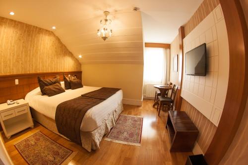 um quarto de hotel com uma cama e uma televisão em Carballo Hotel & Spa em Campos do Jordão