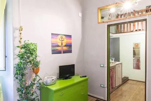 een kamer met een groene ladekast met een televisie erop bij San Gregorio Studio in Napels