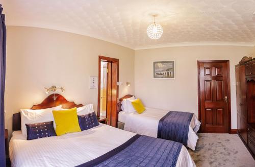 a hotel room with two beds with yellow and blue at The Harp in Killarney