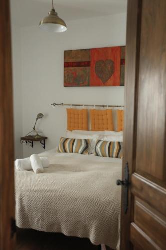 a bedroom with a bed and a painting on the wall at Casa Rural Miller's of Frigiliana in Frigiliana