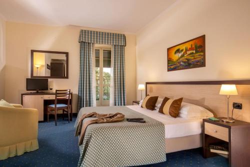 a hotel room with a bed and a desk at Resort La Rocchetta in La Giustiniana