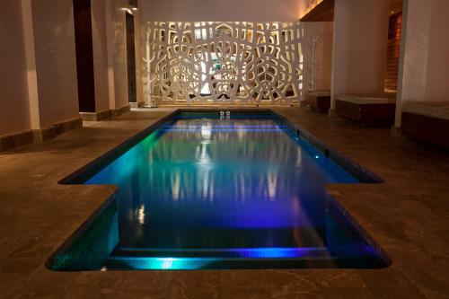 a swimming pool with blue lights in a building at Hotel Esplendido in Port de Soller