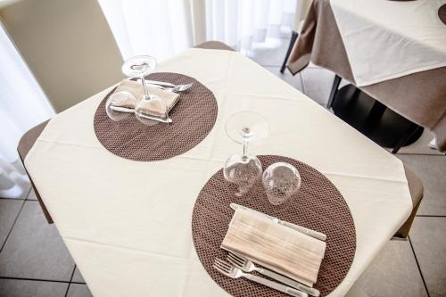 a white table with two plates and glasses on it at All'Orologio - Boutique Hotel in Caorle