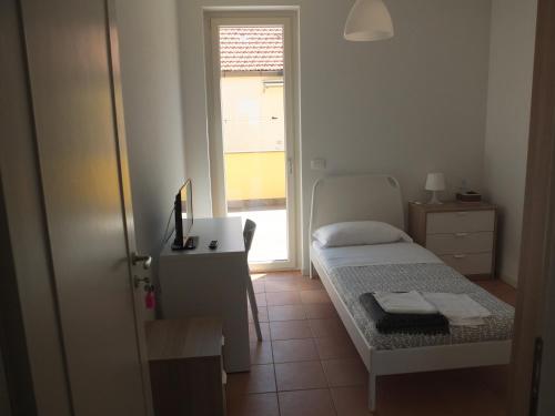 a bedroom with a bed and a desk and a window at La Tortora in Fisciano