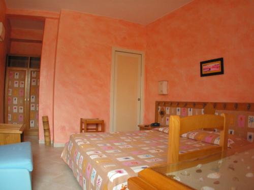 - une chambre avec un lit dans une pièce aux murs orange dans l'établissement Levante Hotel, à San Domino