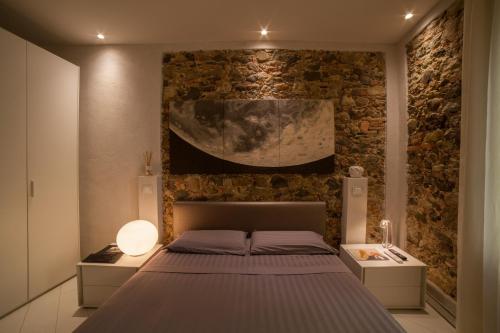 una camera con letto e parete in pietra di Art Boutique Hotel Acchiappasogni a Barga