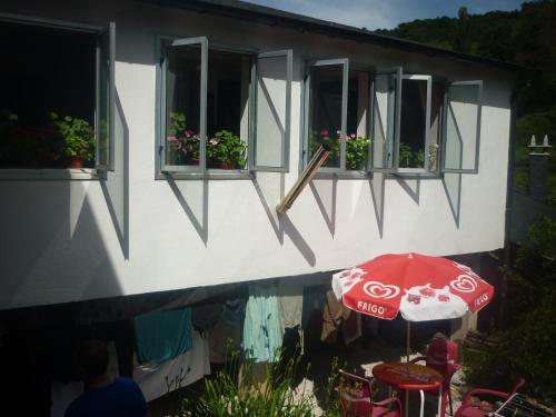 a cocacola umbrella in front of a building with windows at Pensión Santa Rosa in Samos