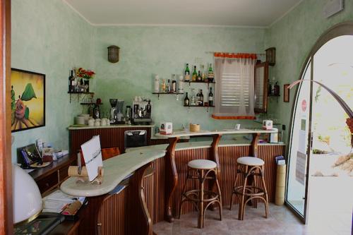 um restaurante com um bar com bancos num quarto em Levante Hotel em San Domino