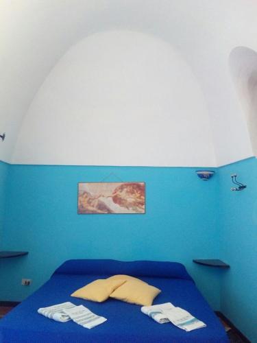 a blue bedroom with a bed with two towels on it at Dammusi La Favarotta in Pantelleria