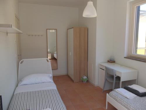 a room with two beds and a desk and a mirror at La Tortora in Fisciano
