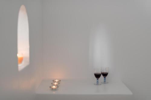 two glasses of wine sitting on a white sink at Katharos Pool Villas in Oia