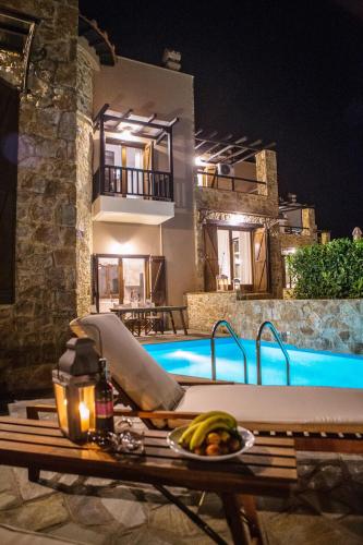 a table with bananas on it next to a swimming pool at S4Sani in Sani Beach