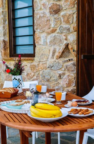 a wooden table with bananas and other food on it at S4Sani in Sani Beach