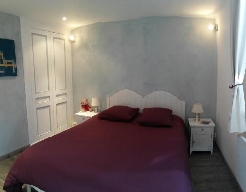 - une chambre avec un lit violet et 2 oreillers rouges dans l'établissement La Petite Fugue, à Honfleur