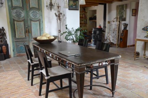 a dining room table with chairs and a laptop on it at Une Demeure d'Exception in Caveirac