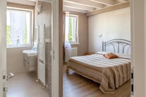 una camera con letto e un bagno con lavandino di Le Bianchette Agriturismo e Fattoria Didattica a Sommacampagna