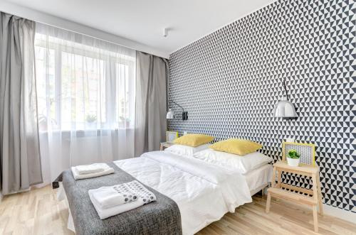 a bedroom with a large white bed and a window at Apartament Marina Dlugie Ogrody in Gdańsk