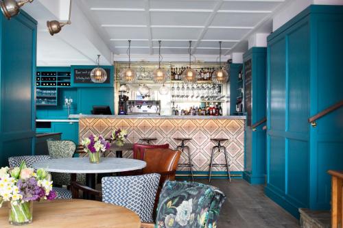 a restaurant with blue walls and a table and chairs at The Bower House, Restaurant & Rooms in Shipston on Stour