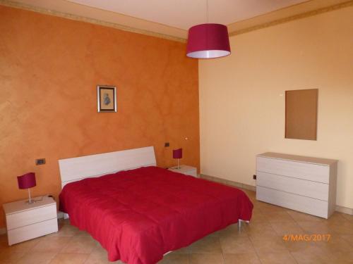 シラクーサにあるAppartamento the Architectのベッドルーム1室(赤いベッド1台、ナイトスタンド2台付)