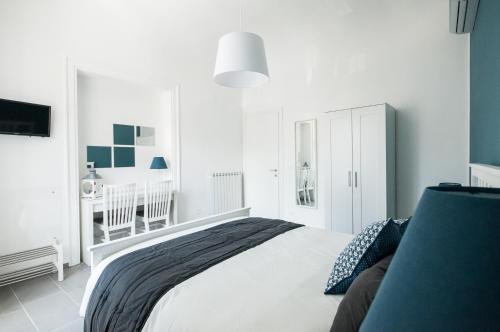 a white bedroom with a bed and a crib at B&B Dietro il Teatro in Palermo