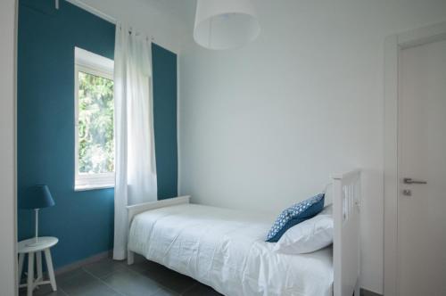 a bedroom with a white bed and a window at B&B Dietro il Teatro in Palermo