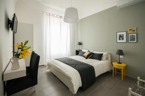Un dormitorio con una cama grande y una mesa amarilla. en B&B Dietro il Teatro, en Palermo