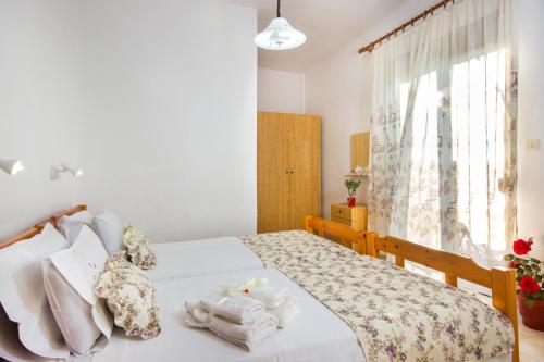 a bedroom with a bed with towels on it at Summer Rooms in Skala Kallirachis