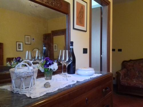 a dresser with wine glasses and flowers on it at Cà D' Rot - Casa Ratti in Vinchio