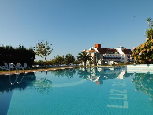 a large swimming pool with buildings in the background at Hotel Luz de Luna in Portonovo