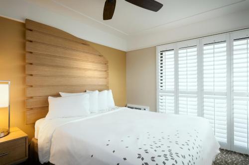 a bedroom with a large white bed with a wooden headboard at Diamond Head Inn in San Diego