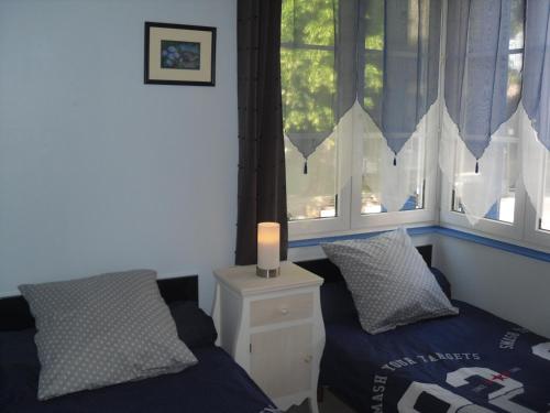 Un dormitorio con una cama y una ventana con una vela en Gites de Daumesnil Appartement La Loob en Morlaix