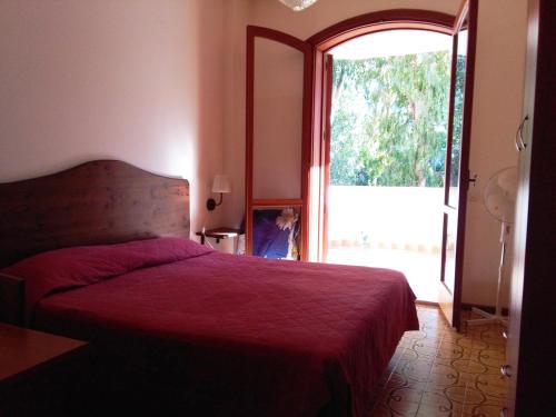 a bedroom with a red bed and a large window at Holiday Home Recanati in Giardini Naxos